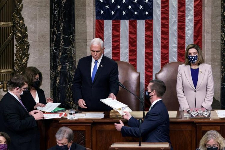 El vicepresidente de EEUU, Mike Pence, da lectura en el Capitolio al acta que confirma al demócrata Joe Biden como el próximo presidente del país, junto a la presidenta de la Cámara de Representantes, Nancy Pelosi. EFE/
