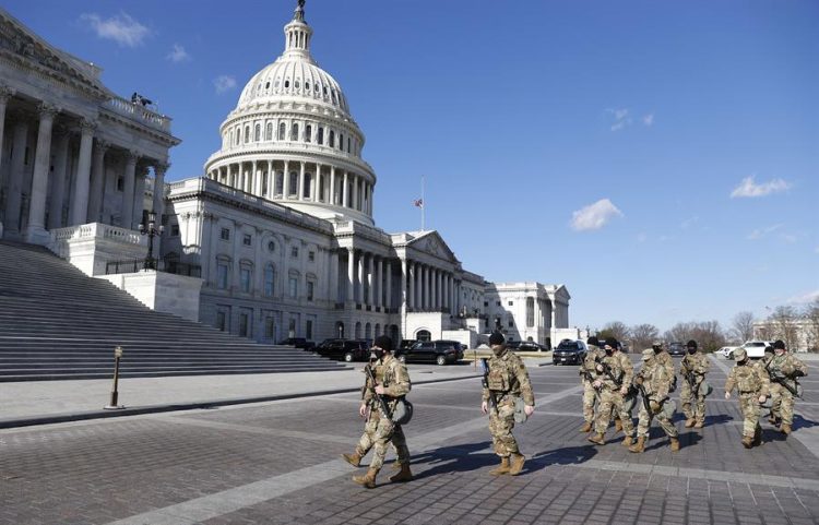 Miembros de la Guardia Nacional de EEUU fueron registrados este martes al caminar frente al Capitolio, durante los preparativos de la investidura del presidente electo de EE.UU., Joe Biden, en Washington DC (EE.UU.). EFE/Erik S. Lesser