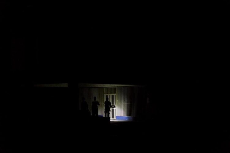 Fotografía de archivo de una persona que ilumina la entrada de su casa durante un corte de energía en Maracaibo (Venezuela). EFE