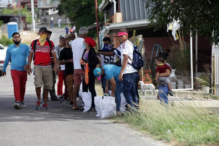 Migrantes venezolanos registrados en la lista del Gobierno de Trinidad y Tobago reciben bolsas de alimentos donados. EFE
