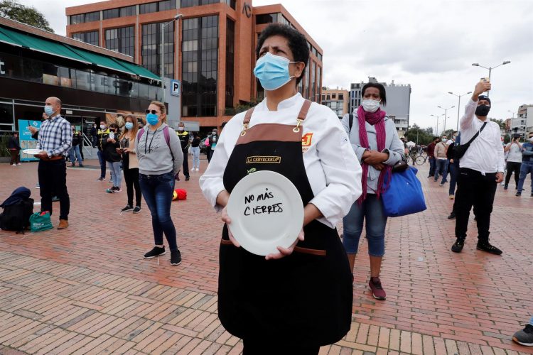 Una mujer sostiene un plato durante una protesta del gremio Asobares, hoy en Bogotá (Colombia). EFE/ Mauricio Dueñas Castañeda