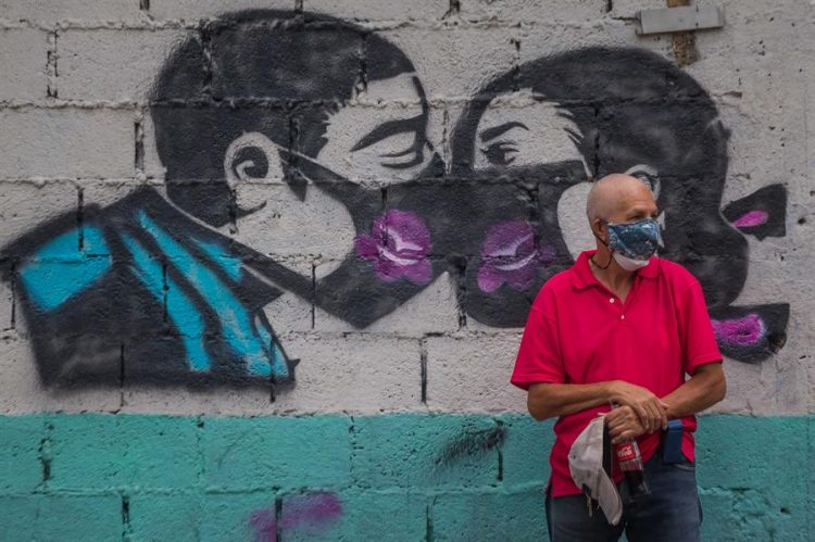 Un hombre permanece junto a un mural alusivo al uso del tapabocas para protegerse de la covid-19 en Caracas (Venezuela). EFE/ Miguel Gutiérrez/Archivo
