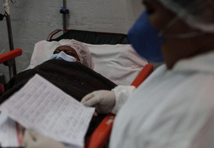 Un paciente contagiado por covid-19 escucha una carta de sus familiares mientras es leída por un miembro del personal de salud, hoy, en el Hospital General de Nova Iguaçú, en el área metropolitana de Río de Janeiro (Brasil). EFE/Antonio Lacerda