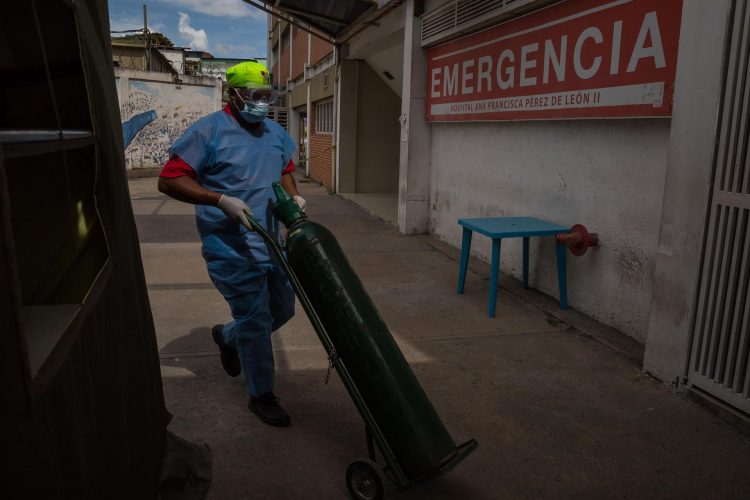 Un trabajador carga una bombona de oxígeno en el área de emergencias de un hospital público en Caracas (Venezuela). EFE/ Miguel Gutiérrez/Archivo