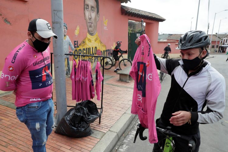 Un vendedor ambulante (i) fue fotografiado este domingo al ofrecer camisetas réplicas de las del líder del Giro de Italia, en Zipaquirá (Colombia), tierra natal de Egan Bernal nuevo campeón de la vuelta ciclística europea. EFE/Carlos Ortega