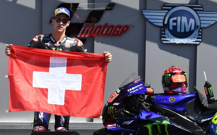 El piloto francés de MotoGP, Fabio Quartararo posaba en el podio del Gran Premio de Italia con una bandera de Suiza, en homenaje a piloto de Moto3 Jason Dupasquier, que ha fallecido este domingo, tras el accudente sufrido ayer en Mugello. EFE/EPA/CLAUDIO GIOVANNINI
