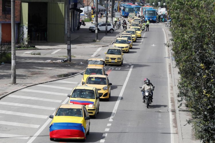 Un grupo de taxistas se moviliza hoy, con banderas de Colombia por las calles de Bogotá. EFE/ Carlos Ortega