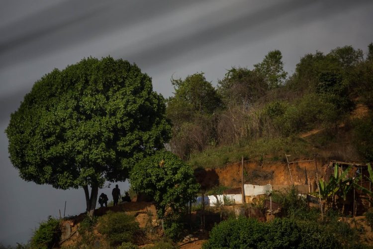 Un grupo de policías se esconden detrás de un árbol en una montaña durante un enfrentamiento con criminales en La Vega, el 07 de junio de 2021, en Caracas (Venezuela). EFE