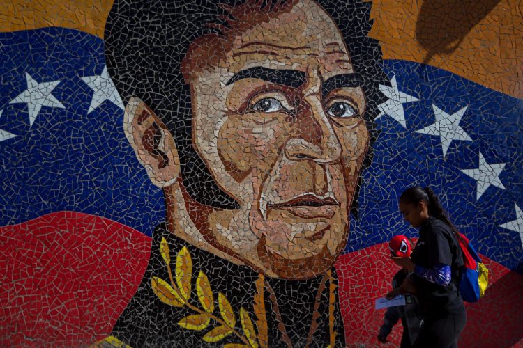 Fotografía del 11 de febrero del 2020 donde se observa un mural con la imagen del héroe nacional Simón Bolivar mientras una mujer camina con un niño que usa una mascara del hombre araña en Caracas (Venezuela). EFE/MIGUEL GUTIERREZ/Archivo