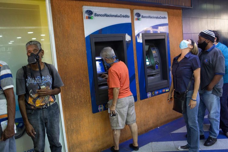 Fotografía del 21 de julio de 2021 que muestra a varias personas que acuden a hacer retiros de dinero en efectivo a cajeros automáticos, en Caracas (Venezuela). EFE/ Manaure Quintero