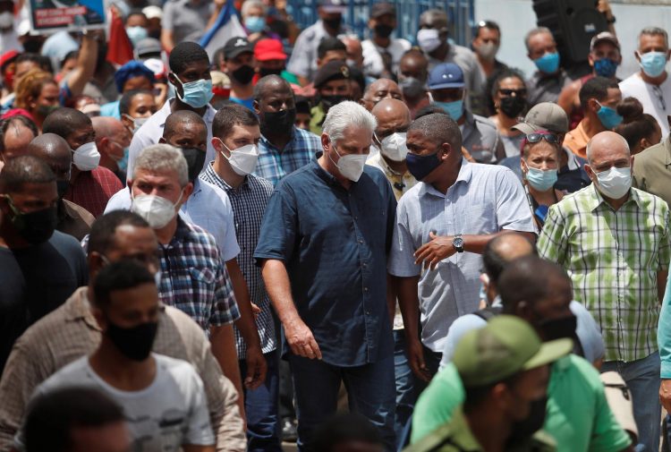 El presidente de Cuba Miguel Díaz-Canel (c) camina acompañado por Alpidio Alonso (d) y otros simpatizantes hoy, por una calle del pueblo San Antonio de los Baños (Cuba). EFE