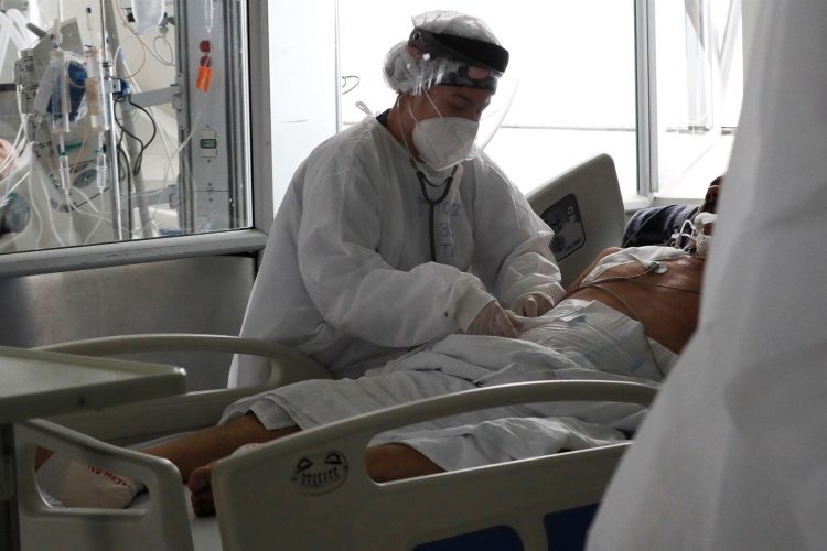 Una empleada de la salud atiende a un paciente en una unidad de cuidados intensivos para enfermos de covid-19 en el Hospital El Tunal en Bogotá (Colombia). EFE/Carlos Ortega/Archivo
