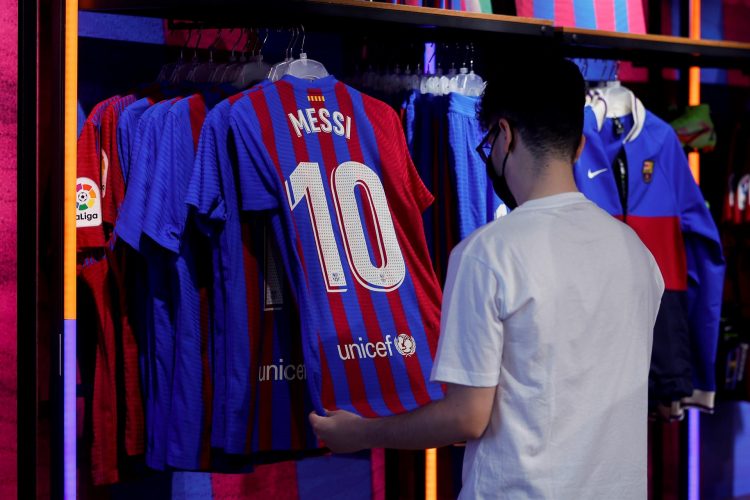 Un aficionado observa una camiseta de la estrella argentina del FC Barcelona, Leo Messi, en la tienda oficial del club azulgrana, este jueves, después de que ayer, 30 de junio, Messi haya quedado desvinculado oficialmente del club al finalizar su contrato, aunque el FC Barcelona espera cerrar, en los próximos días, la continuidad del delantero argentino. EFE/Quique Garcia