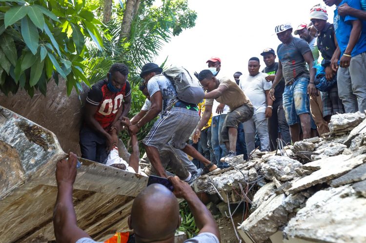 Un grupo de personas sacan el cuerpo sin vida del senador Jean Gabriel Fortuné (arriba-i), tras un seísmo de 7,2 grados ayer en Los Cayos (Haití). EFE/ Ralph Tedy Erol