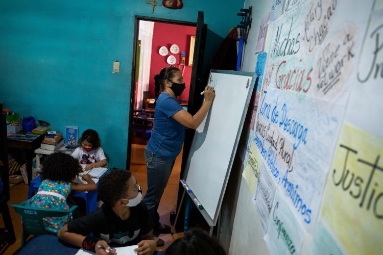 La maestra Jasmín Castro escribe en una pizarra durante una clase en su casa, el 20 de agosto de 2021, en Petare, Caracas (Venezuela). EFE/Rayner Peña R.
