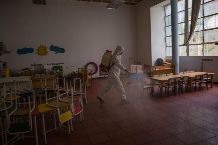 Trabajadores gubernamentales participan en una jornada de desinfección por covid-19 en un colegio público en Caracas. Venezuela. EFE/Miguel Gutiérrez/Archivo