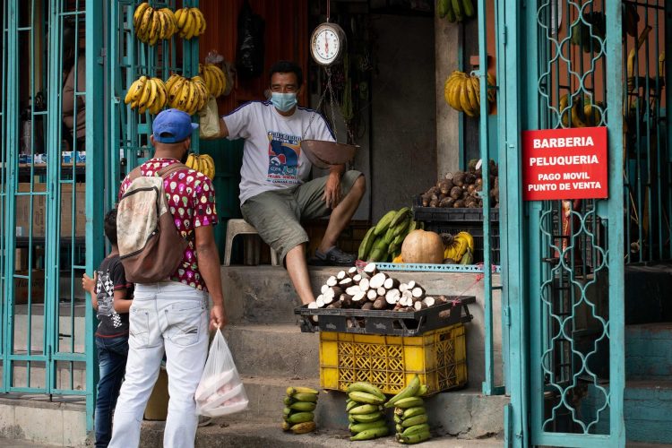 Un hombre compra en un puesto de frutas, en Caracas (Venezuela). EFE/Rayner Peña R/Archivo