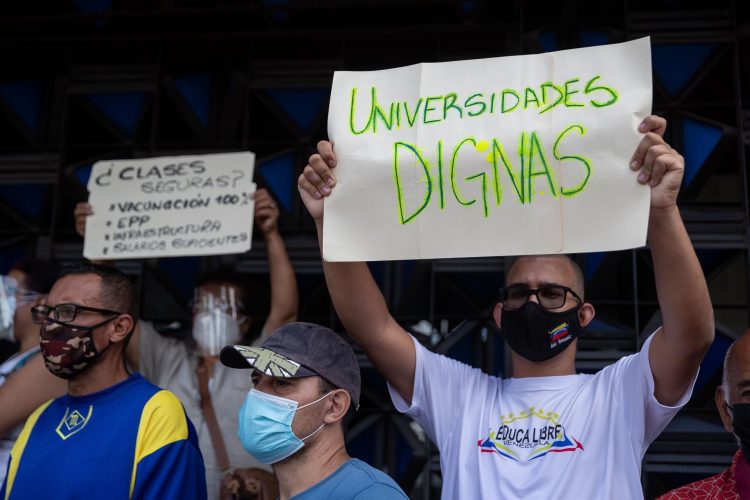 Un hombre carga una pancarta que dice "Universidades dignas" durante una protesta por mejores condiciones laborales frente al Ministerio de Educación hoy en Caracas (Venezuela). EFE/Rayner Peña