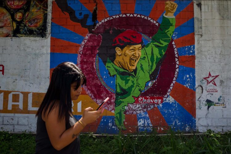 Una mujer camina junto a un mural sobre el fallecido presidente venezolano Hugo Chávez, el 8 de noviembre de 2021 en Caracas (Venezuela). EFE/Miguel Gutiérrez