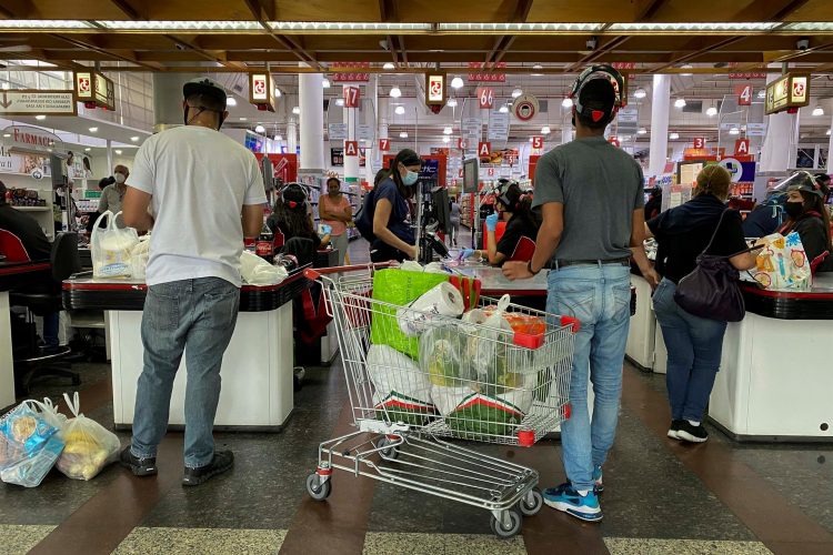 Personas hacen fila para pagar sus mercados en Caracas, Venezuela, en una fotografía de archivo. EFE/Rayner Peña
