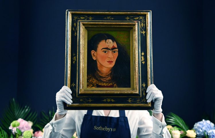 Vista del personal de la casa de subastas de Sotheby's con el autorretrato de la artista mexicana Frida Kahlo, titulado 'Diego y yo', en una fotografía de archivo. EFE/EPA/ANDY RAIN