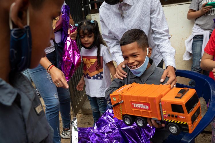 Un niño reacciona luego de abrir un regalo de "Un Juguete, una buena noticia" hoy, en Caracas (Venezuela). EFE/ RAYNER PEÑA R.
