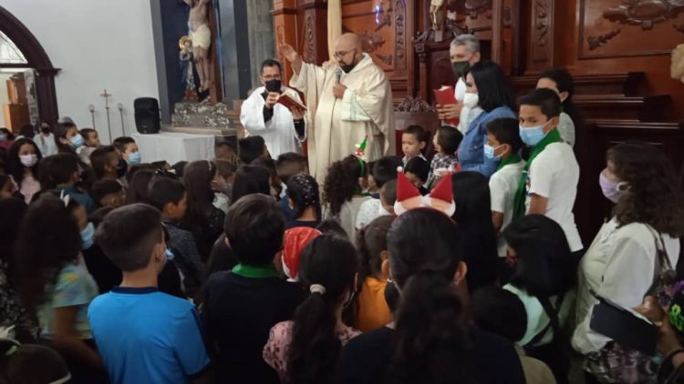 Padre Juan Carlos Mendoza Montilla, desde el Altar Mayor impartiendo la bendición a todos los niños.