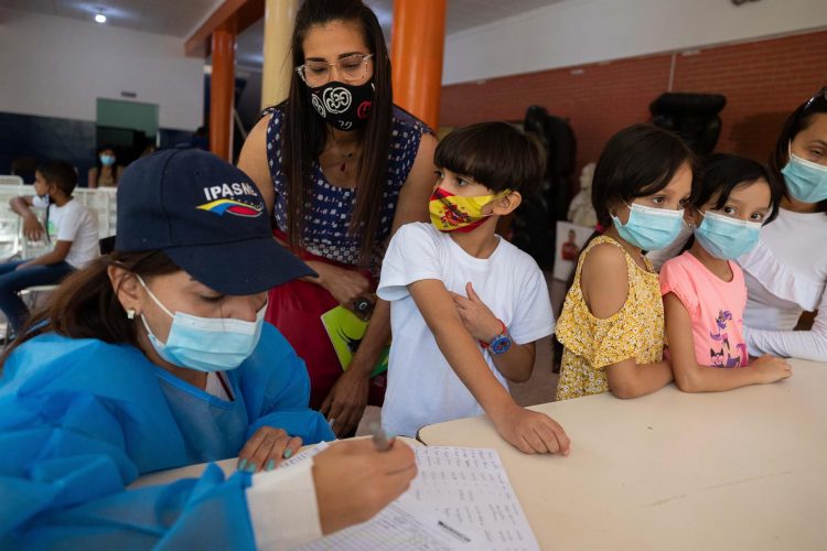 Una funcionaria del sector salud fue captada al hacer el registro de niños vacunados contra la covid-19, en un colegio, en Caracas (Venezuela).EFE/Rayner Peña