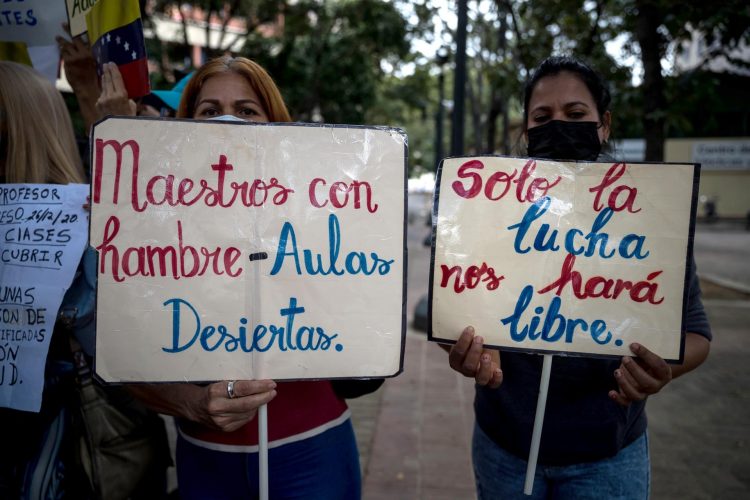 Dos mujeres sostienen carteles en una manifestación, en Caracas (Venezuela), en una fotografía de archivo. EFE/Miguel Gutiérrez