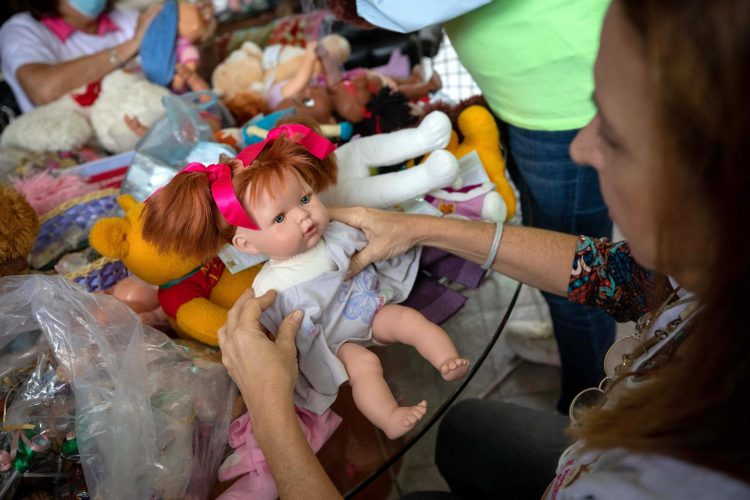 Una voluntaria cambia la ropa de una muñeca en la fundación Hospital de Peluches,