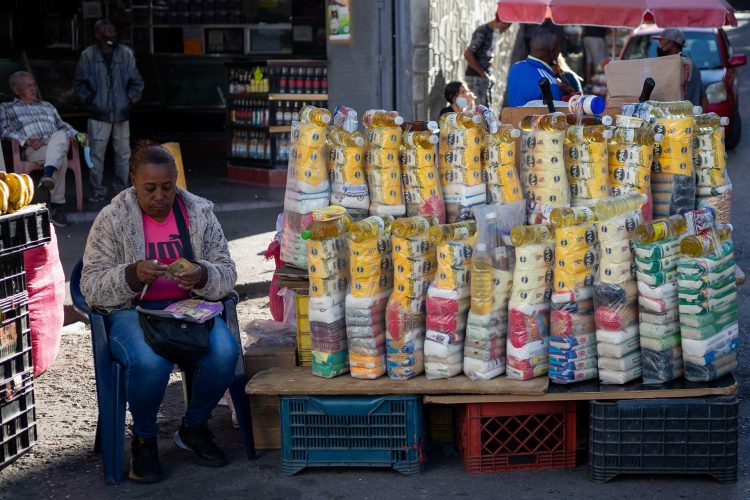 Una vendedora cuenta billetes de dólar mientas esperan clientes en un puesto de comida, el 18 de enero de 2022, en Caracas (Venezuela). EFE/ Rayner Peña R.