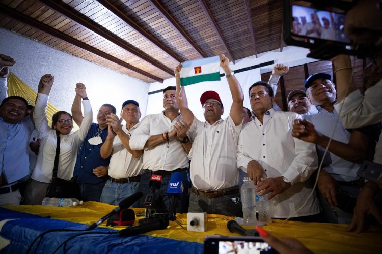 Sergio Garrido (c), muestra la bandera del estado durante una rueda de prensa hoy, desde su comando de Campaña en Barinas (Venezuela). EFE