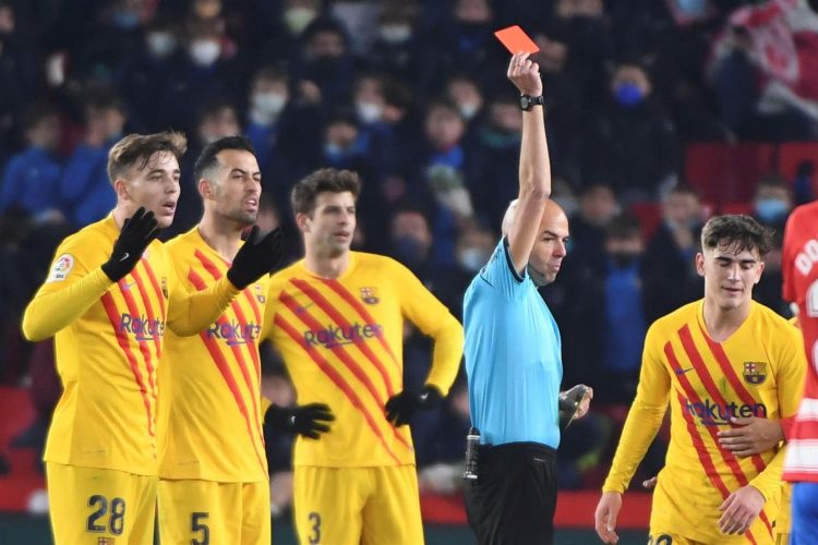 El centrocampista del FC Barcelona, Gavi (d) recibe una cartulina roja durante el partido de LaLiga entre el Granada y el Barcelona, en el Nuevo Los Cármenes. EFE/ Miguel Ángel Molina