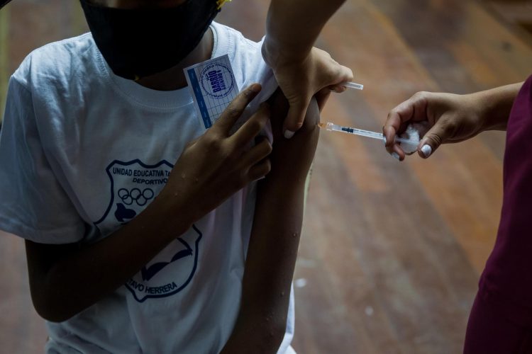 Menores de edad asisten a un centro de vacunación en una escuela en Caracas (Venezuela)