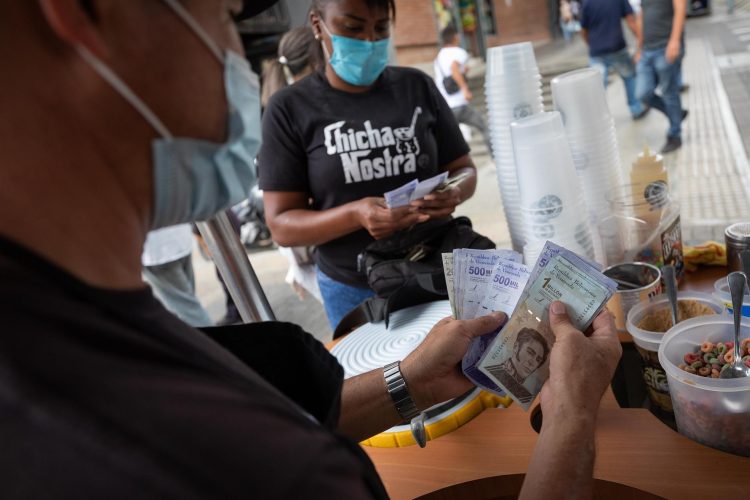 Vendedores cuentan billetes del antiguo cono monetario (Bolívar Soberano), el 22 de octubre de 2021, en Caracas (Venezuela). EFE
