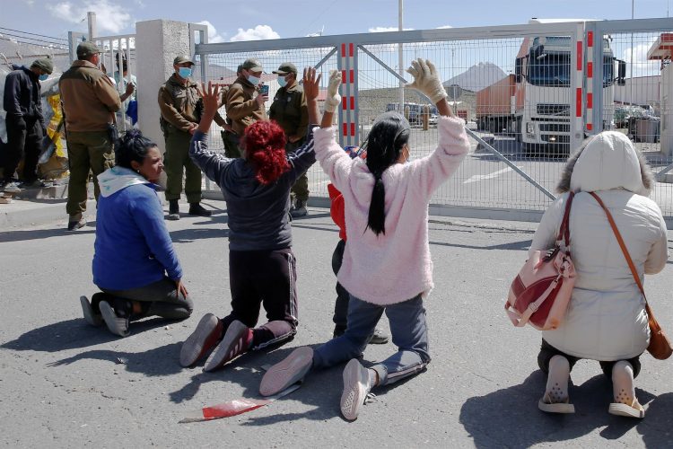 Un grupo migrantes protesta, el 13 de febrero de 2022, contra el cierre de la frontera entre Chile y Bolivia situada en la comuna de Colchane (Chile). EFE/José Caviedes