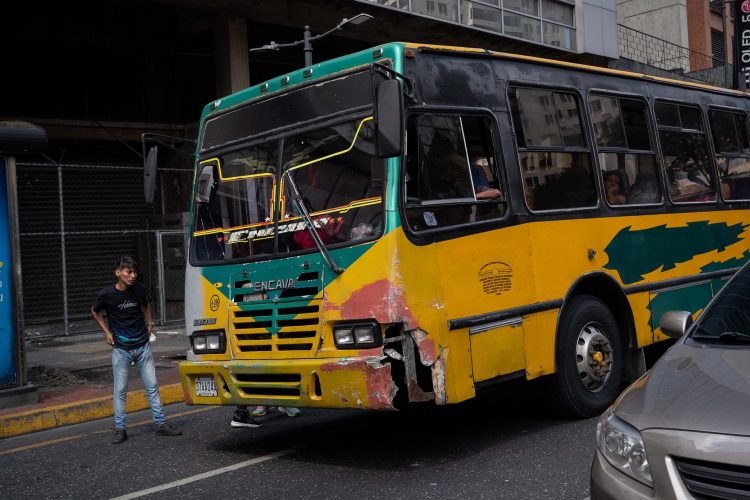 Un transportista espera pasajeros junto a un autobús, el 16 de febrero de 2022, en Caracas (Venezuela). EFE/Rayner Peña R.