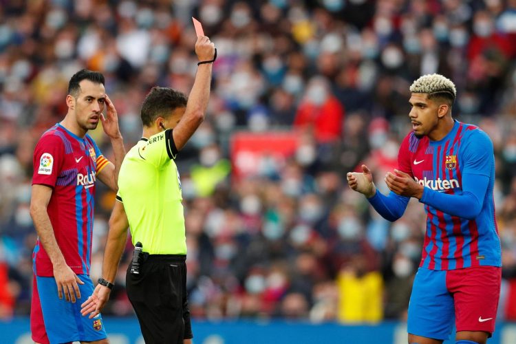 El árbitro Gil Manzano (i) saca la tarjeta roja al defensa del FC Barcelona Dani Alves ante el defensa uruguayo Ronald ARaújo (d) y Busquets (i) durante el partido de Liga que FC Barcelona y Atlético de Madrid disputaron en el estadio Camp Nou de Barcelona. EFE/