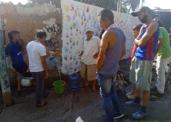 Valeranos hacen cola para poder llenar sus pimpinas de agua