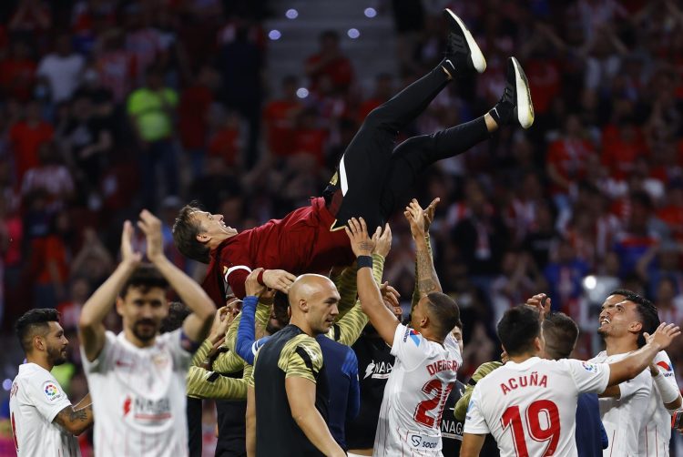 Los jugadores del Sevilla mantean a su entrenador Julen Lopetegui al término del partido correspondiente a la jornada 37 de primera división disputado ante el Atlético de Madrid este domingo en el Wanda Metropolitano. . EFE