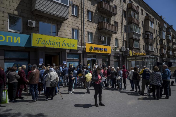 Un grupo de personas hacía cola ante un centro humanitario para recibir ayuda en la ciudad ucraniana de Zaporiyia. EFE