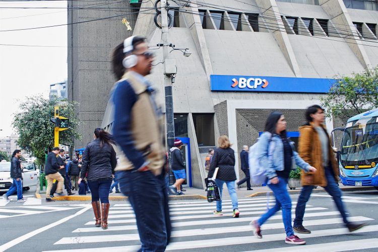 Fotografía de archivo fechada el 15 de septiembre de 2019 que muestra a varias personas mientras pasan frente a una sede del banco BCP, en Lima (Perú). IEFE/ Christian Ugarte