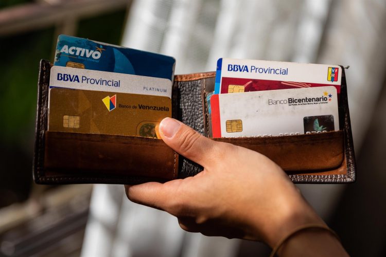 Una mujer muestra una cartera con tarjetas de crédito de diferentes instituciones bancarias hoy, en Caracas (Venezuela). EFE/ Rayner Peña R.