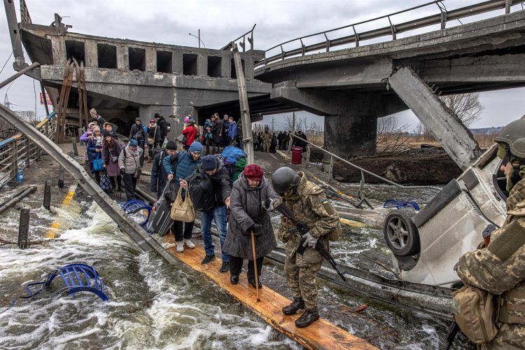 Decenas de civiles cruzaban por un puente semi destruido por los ataques rusos en el ciudad de Irpin,en la región ucraniana de Kiev, el pasado mes de marzo EFE/