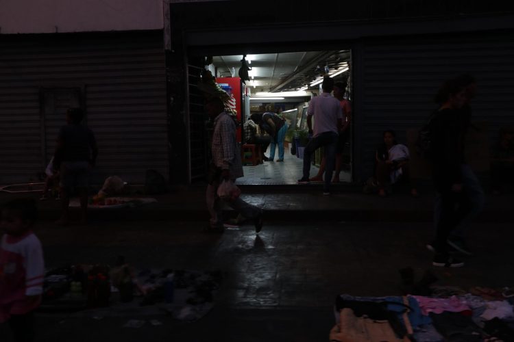 Comerciantes abren sus locales mientras la calle permanece a oscuras por la falta de fluido eléctrico en Caracas, en una fotografía de archivo. EFE/Rayner Peña