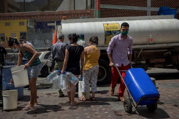 Personas hacen fila para abastecerse de agua en el centro de Caracas (Venezuela), en una fotografía de archivo. EFE/Rayner Pena R.