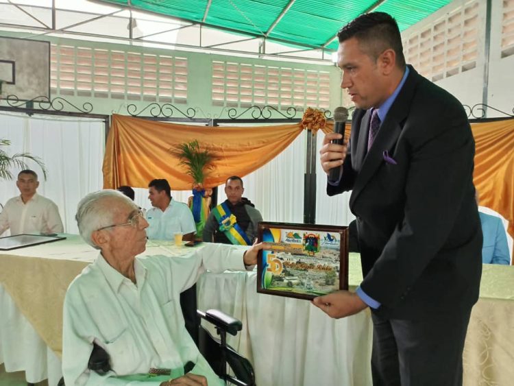 Presidente del Concejo Municipal Yeison Cabrera entrega reconocimiento a Walter Márquez, al fondo el alcalde municipal Abdul Salcedo