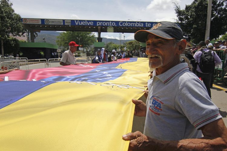 Un grupo de personas sostiene una bandera en el puente Simón Bolívar durante un acto de reapertura de la frontera entre Colombia y Venezuela hoy, en Cúcuta (Colombia). EFE/Mario Caicedo