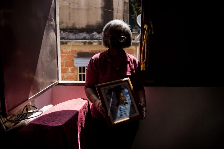 Ana (nombre ficticio) posa con un retrato de su hijo, el 9 de septiembre de 2022, en Caracas (Venezuela). EFE/ Miguel Gutiérrez
