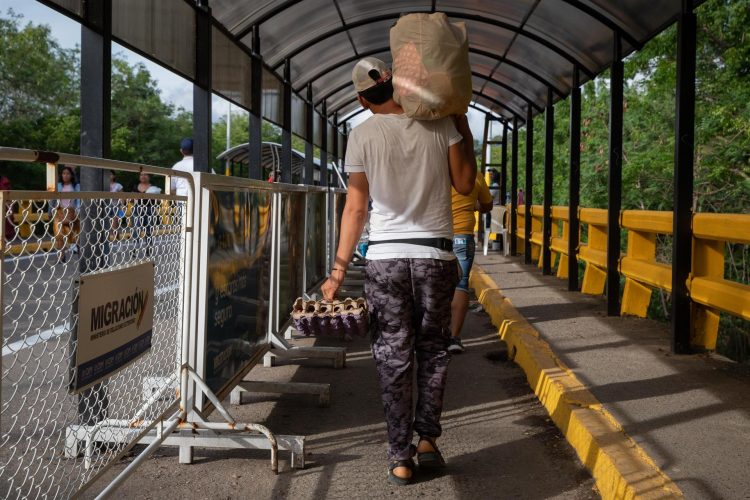 Fotografía de archivo fechada el 25 de septiembre de 2022 que muestra a un hombre mientras carga un mercado por el Puente Internacional Simón Bolívar, Cúcuta, Norte de Santander (Colombia). EFE/Rayner Peña R.